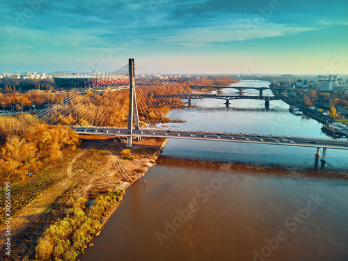 Beautiful panoramic aerial dsrone view to Swietokrzyski Bridge (Polish: Świętokrzyski) and The PGE Narodowy or National Stadium - football stadium located in Warsaw, Poland in autumn evening at sunset