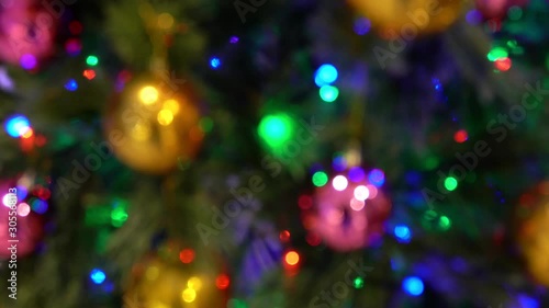 Christmas decoration with hanging ornaments and lights on tree, defocused with blurred colorful blinking  lights bokeh in 4k