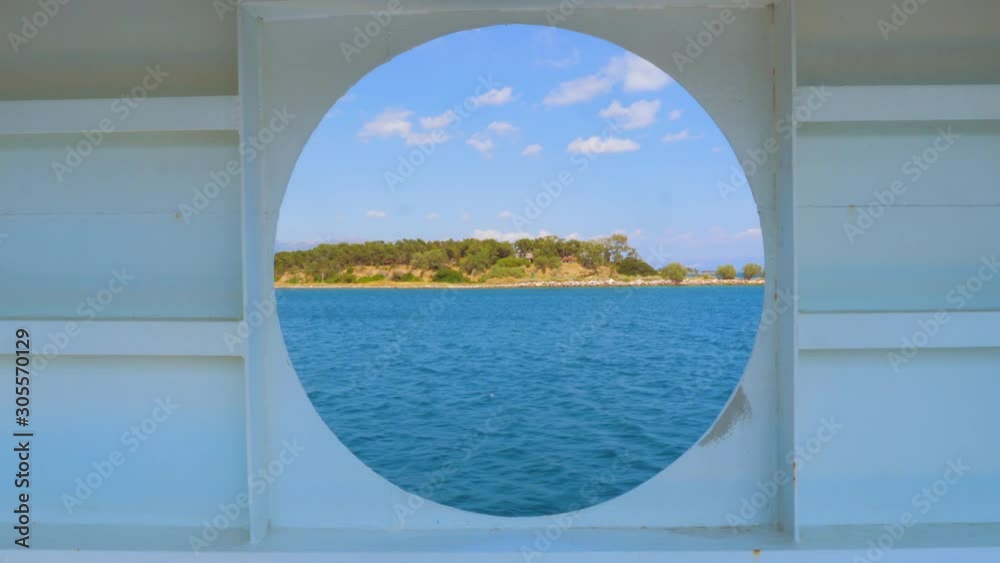 City summer landscape view of Greece seen from inside a ship cabin with round peep-hole window. Round window in a shabby wall with brush marks and a sea view clipping path included City summer landscape view of Greece seen from inside a ship cabin with round peep-hole window. Round window in a shabby wall with brush marks and a sea view clipping path included