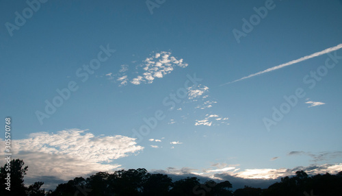 Mixed cloud type image. White Altostratus, Nimbocumulus and Vapout trail cloud in blue sky. Australia.