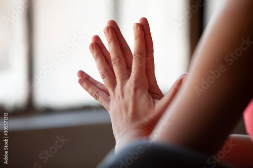 Extreme close up of womans hands pressed together while she practices yoga