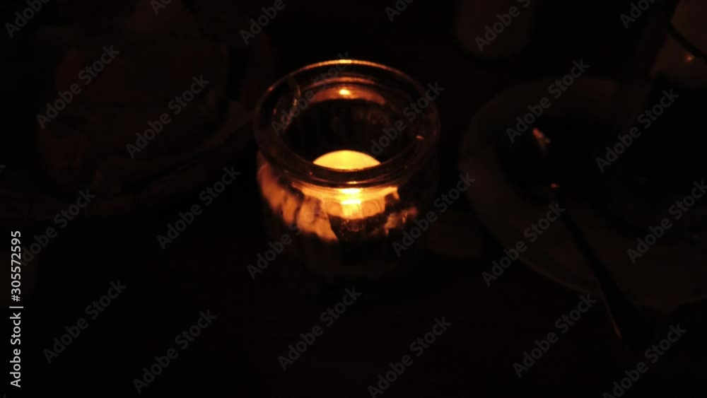 Candle bunning in the glass on tabletop in cafe Candle bunning in the glass on tabletop in cafe