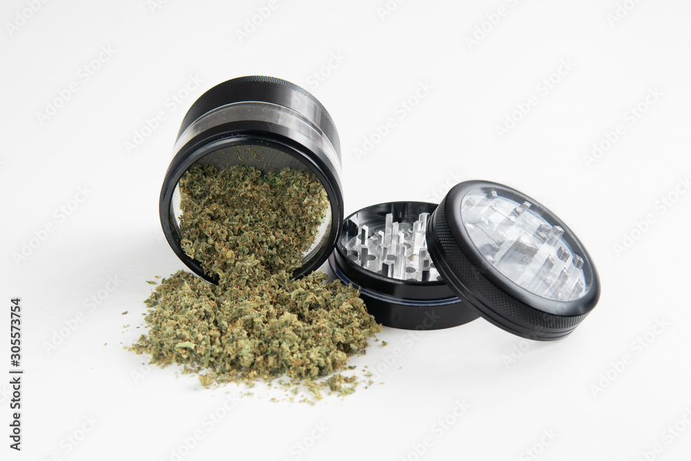 Weed grinder Fresh marihuana. Close up. CBD and THC on buds in cannabis.  Cannabis buds on white wood background. Copy space. Stock Photo