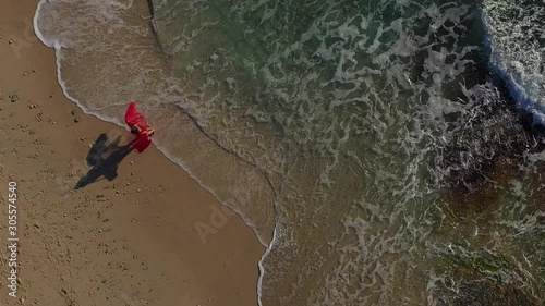 a girl in a red dress runs and dances on the beach es Trenc Majorca Spain