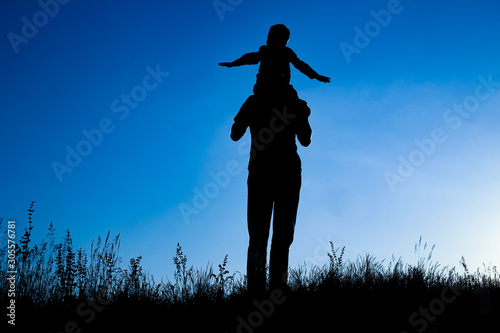 happy parent with child in the park outdoors silhouette