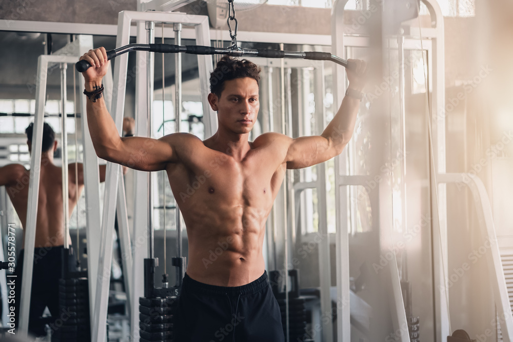 Fototapeta premium caucasian man in fitness having workout for bodybuilding with weights lifting using gym equipment