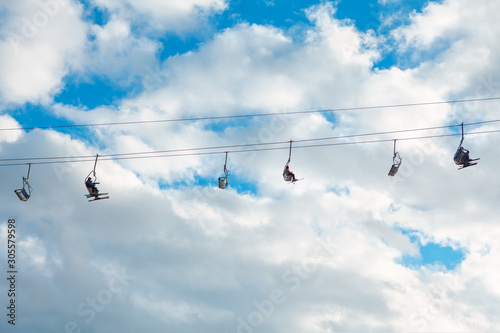 rope with skiers against blue sky