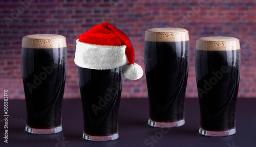 Photography Dry stout beer dark pints with a Holiday santa hat