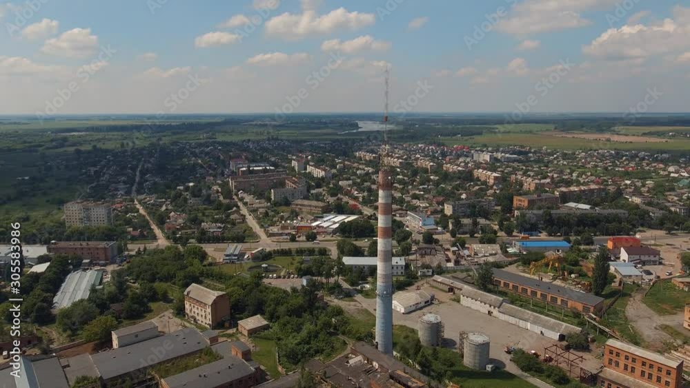 View of the industrial zone of the city. Urban manufacturing infrastructure. High antenna cellular and telecommunications on a large factory pipe. Aerial survey View of the industrial zone of the city. Urban manufacturing infrastructure. High antenna cellular and telecommunications on a large factory pipe. Aerial survey