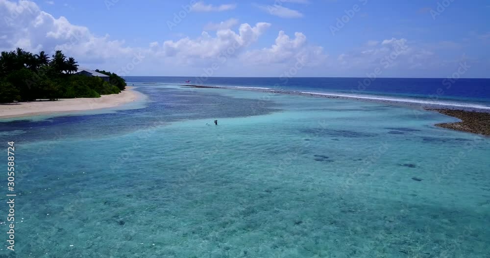 Tranquil clear water of seashore close to tropical island cape with lush vegetation surrounded by coral reef barrier on a bright sky background in Turks and Caicos Tranquil clear water of seashore close to tropical island cape with lush vegetation surrounded by coral reef barrier on a bright sky background in Turks and Caicos