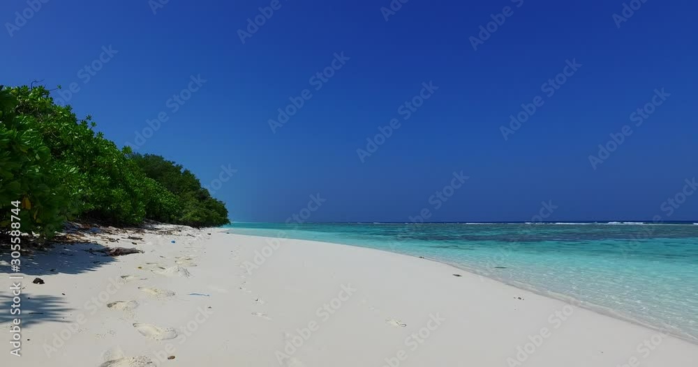 Paradise white sandy beach next to lush vegetation of tropical island wet by calm clear water of turquoise sea under clear blue sky in Barbados Paradise white sandy beach next to lush vegetation of tropical island wet by calm clear water of turquoise sea under clear blue sky in Barbados