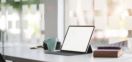 Close-up view of modern office room with blank screen digital tablet with office supplies