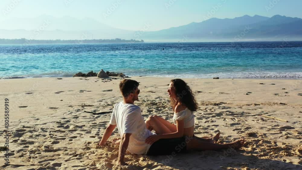 Island of Bahamas - Couple having romantic time together on the sandy beach near the shoreline with deep blue sea and mountain stretch on the background - Panoramic Shot Island of Bahamas - Couple having romantic time together on the sandy beach near the shoreline with deep blue sea and mountain stretch on the background - Panoramic Shot