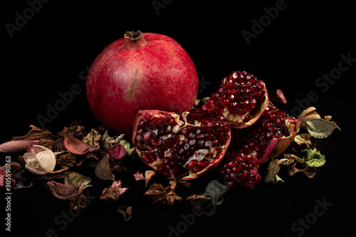 ripe pomegranate rustic style on black isolated background still life photo