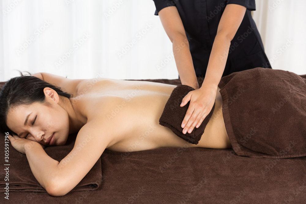 Obraz premium タオルで背中を拭く女性