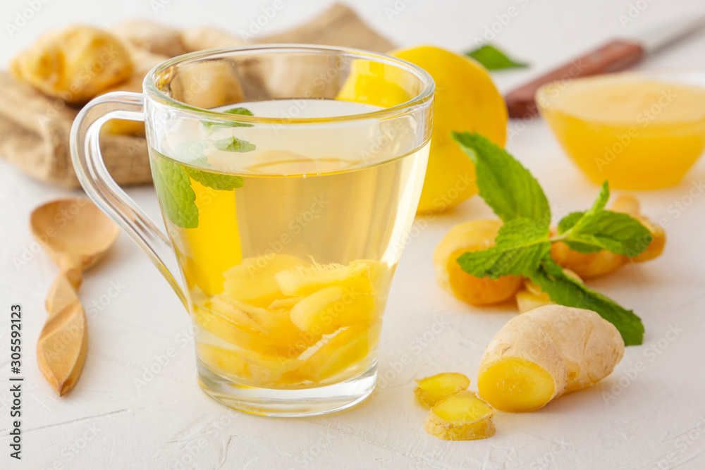Ginger tea with lemon, honey and mint on a white wooden table. Close-up Ginger tea with lemon, honey and mint on a white wooden table. Close-up