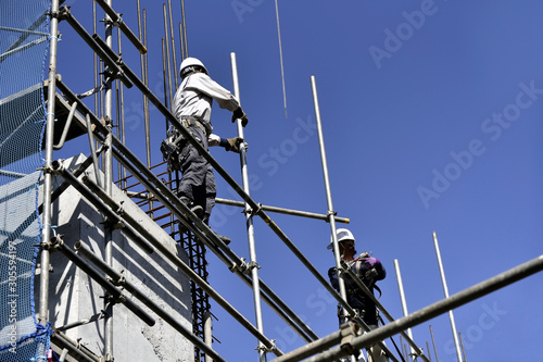 High-rise building site: steeplejack building up scaffolds photo