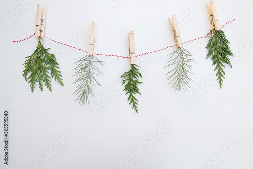 Evergreen Foliage close pinned to a white and red string