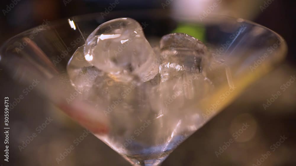 close up of a cocktail glass, bartender making a cocktail pouring ice cubes and alcohol at Havana Cuba close up of a cocktail glass, bartender making a cocktail pouring ice cubes and alcohol at Havana Cuba