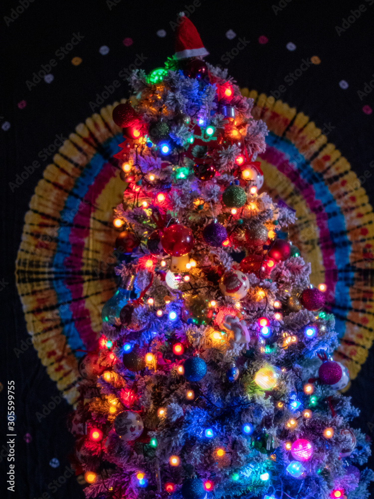 Christmas tree decorated with many bright garlands, balls and toys. Glowing holiday lights sparkle and blink. Element of the New Year mood. 2020 Christmas eve
