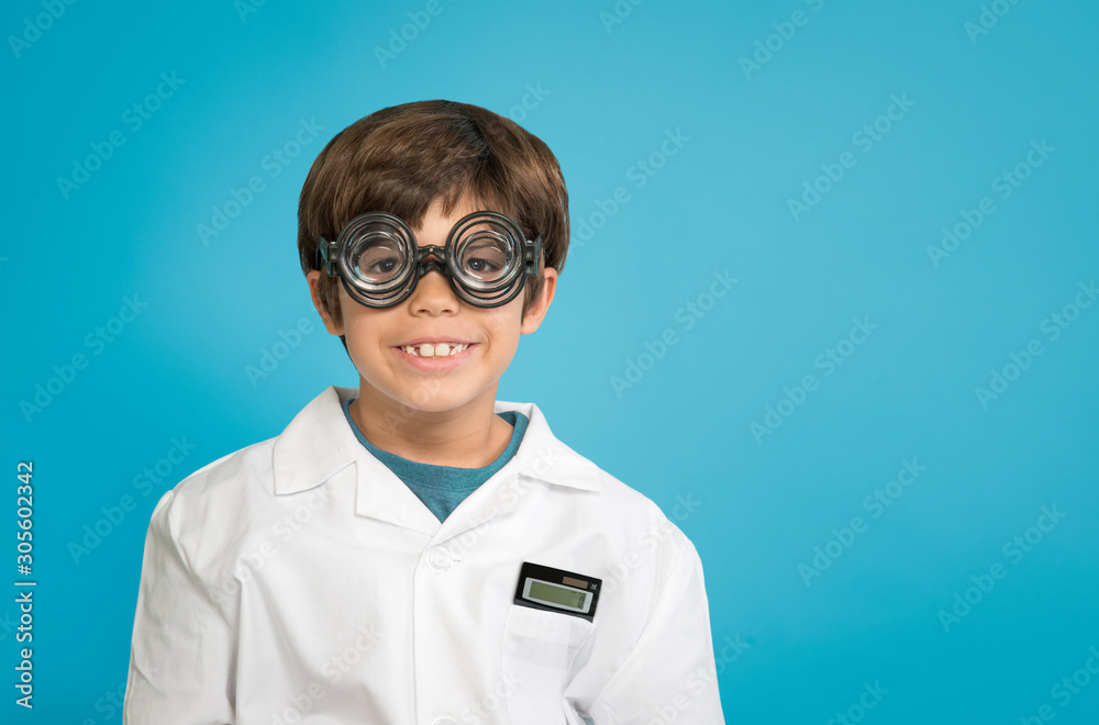 Boy scientist researcher in white lab coat with calculator and double glasses isolated on blue background Boy scientist researcher in white lab coat with calculator and double glasses isolated on blue background
