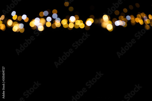 Canvas Print Golden glitter bokeh lights on black background, unfocused