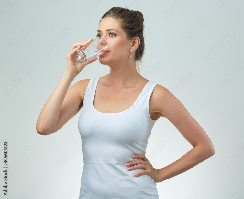 young woman in white sport vest drinking water from glass. young woman in white sport vest drinking water from glass.