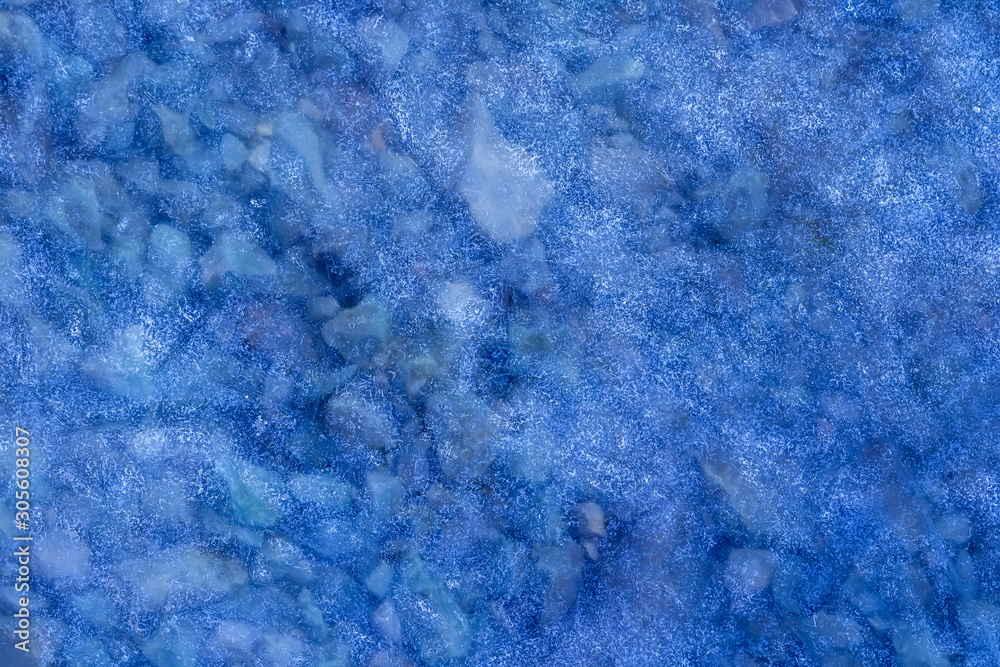 blue texture of an thin ice surface with pure transparent water with stone bottom ,cold clear snow cryslallized background ,winter frozen lake side close up , abstract macro wallpaper blue texture of an thin ice surface with pure transparent water with stone bottom ,cold clear snow cryslallized background ,winter frozen lake side close up , abstract macro wallpaper