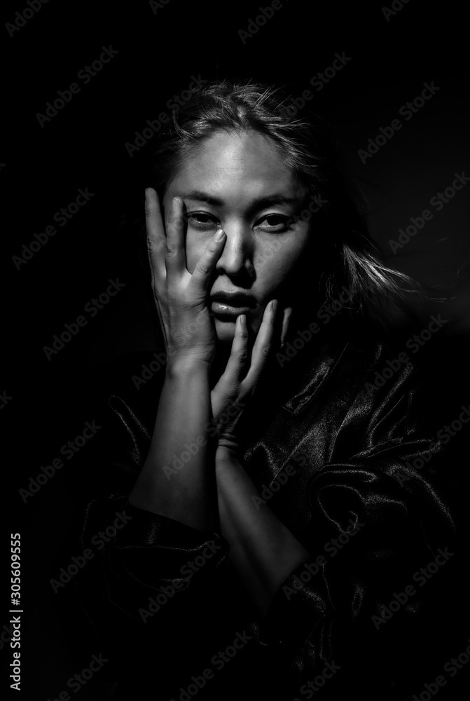 Portrait of a blonde in black clothes on a black background.