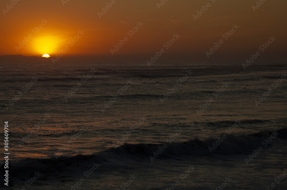 Beautiful California surf and sand sunset Surfers and children play on beach and ocean landscape scenery