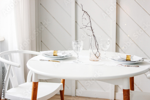 Festive table set for two, minimalistic Christmas decor. Scandinavian interior