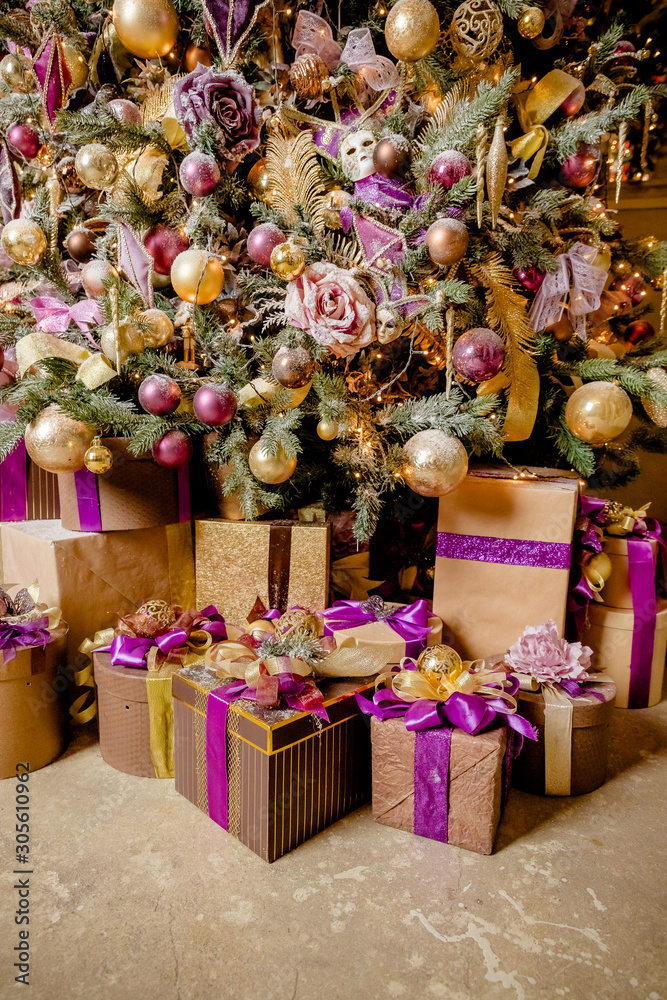 Christmas background with purple, golden decoration, presents.Christmas decoration. purple gift boxes under Christmas tree . winter, new year concept.New Year's Eve with decorations. Selective focus