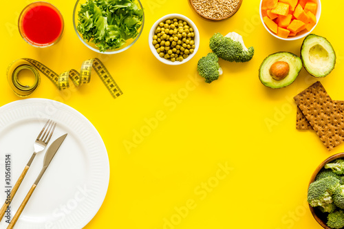 Diet program concept. Empty plate, measure tape and vegetables on yellow background top view copy space