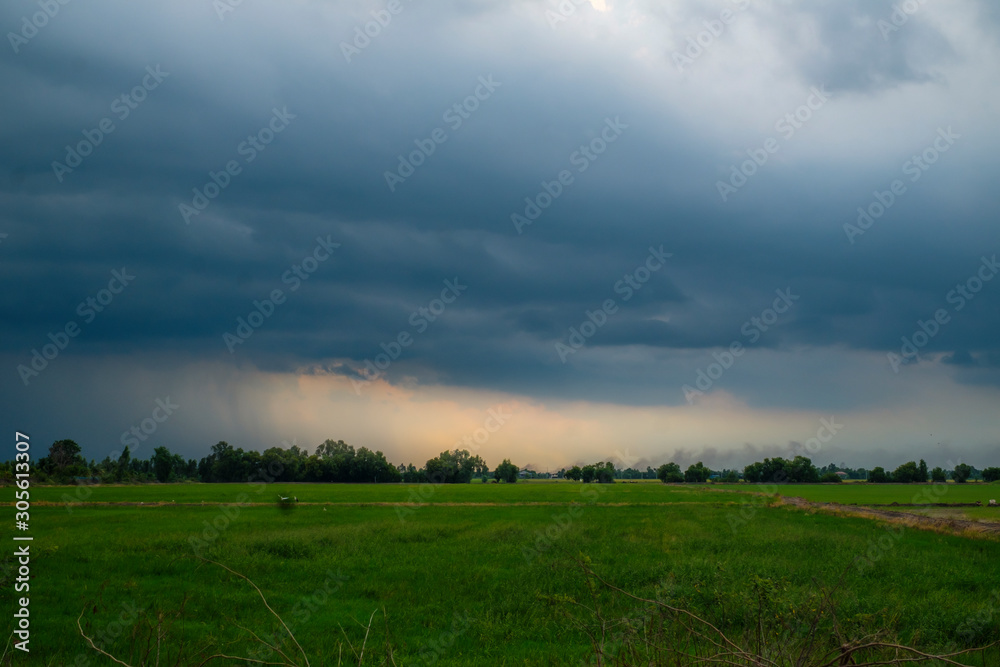 Cloudstorm before heavy rain in farmland at sunset