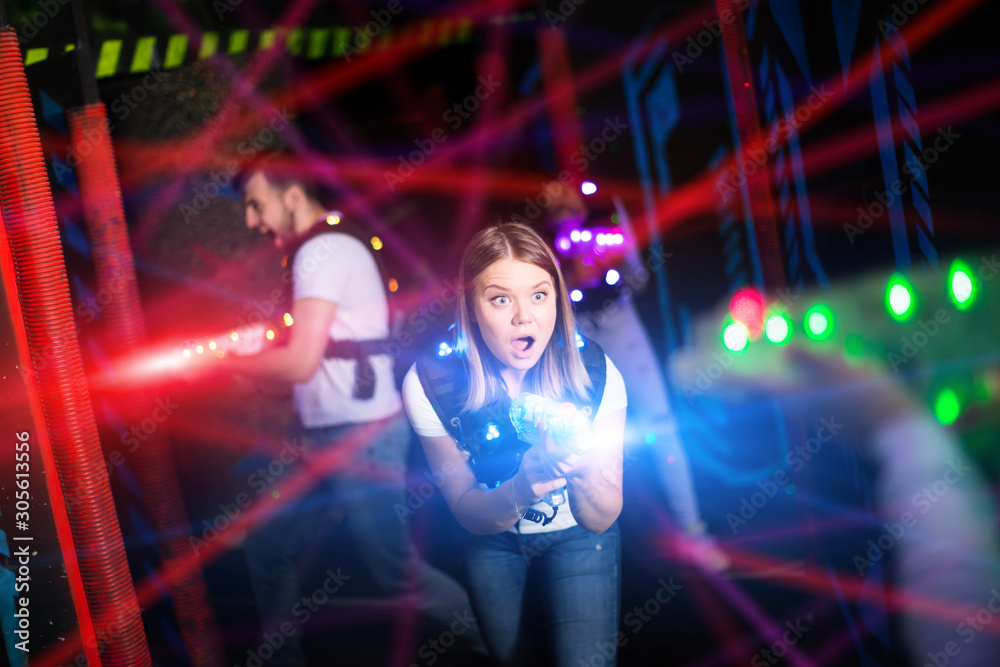 Girl in colored beams during laser tag game