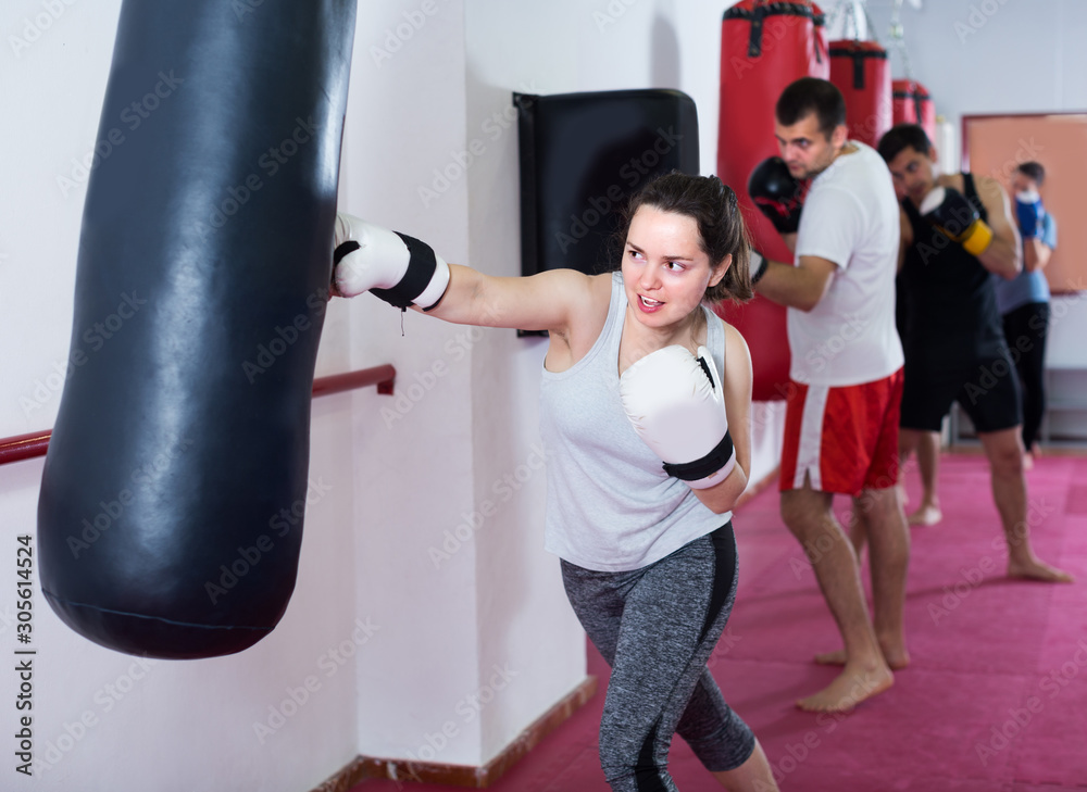 Portait of female which is beating a boxing bag