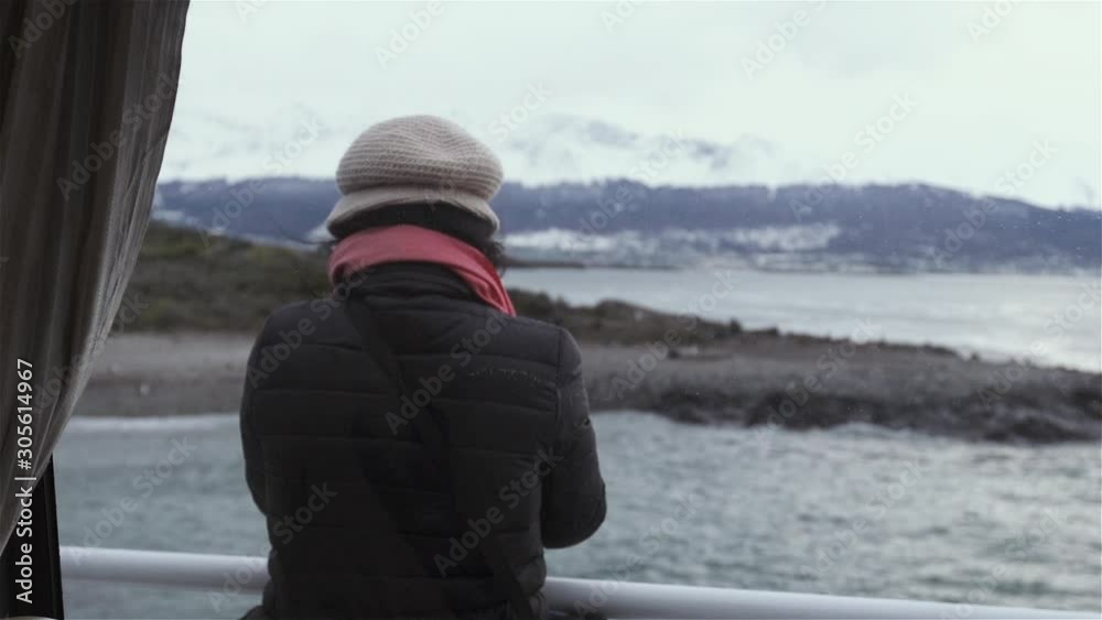 Young Asian Woman Looking at the Beagle Channel from a Tourist Boat, in Patagonia, Argentina. Back View. Young Asian Woman Looking at the Beagle Channel from a Tourist Boat, in Patagonia, Argentina. Back View.
