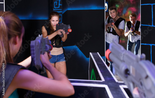 Girls and guys playing lasertag game opposite each other in labyrinth