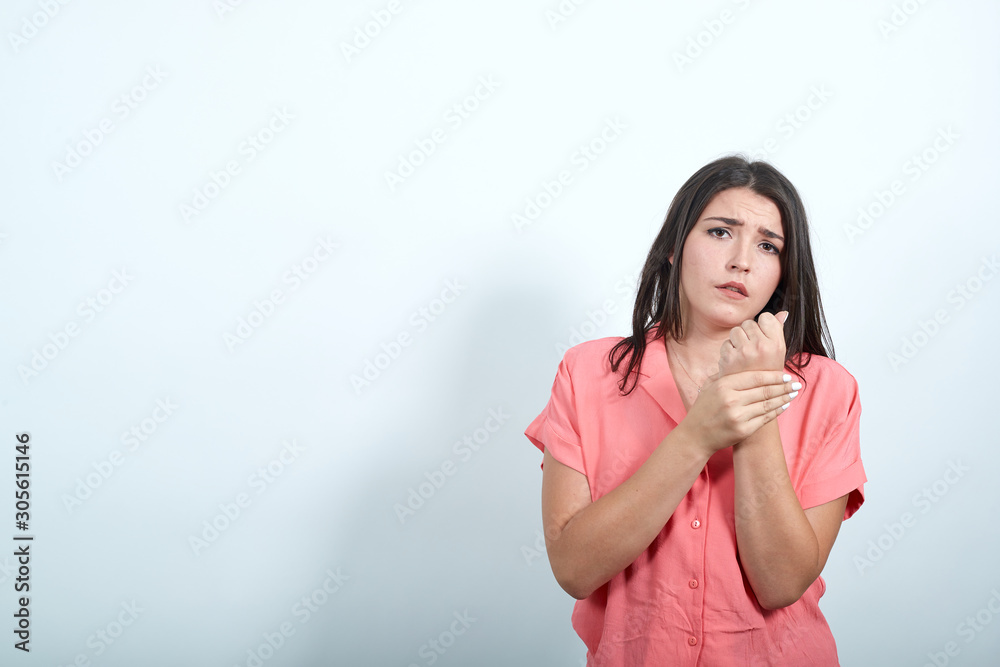 Boring caucasian young woman in pink shirt doing massage on hands, looking sad isolated on white background in studio. People sincere emotions, lifestyle concept. Boring caucasian young woman in pink shirt doing massage on hands, looking sad isolated on white background in studio. People sincere emotions, lifestyle concept.