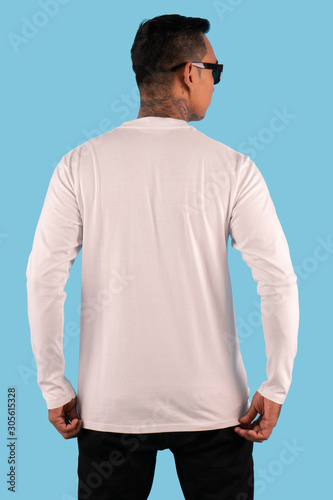 Man wearing white long sleeve t-shirt in back view isolated on plain background © DendraCreative