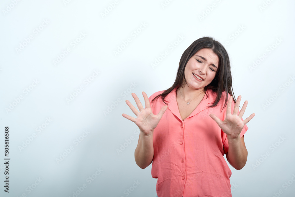Attractive caucasian young woman in pink shirt keeping palms directly isolated on white background in studio. People sincere emotions, lifestyle concept. Attractive caucasian young woman in pink shirt keeping palms directly isolated on white background in studio. People sincere emotions, lifestyle concept.