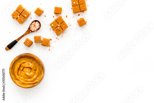 Trendy sweets - salted caramel - melted and cubes on white background top view copy space photo