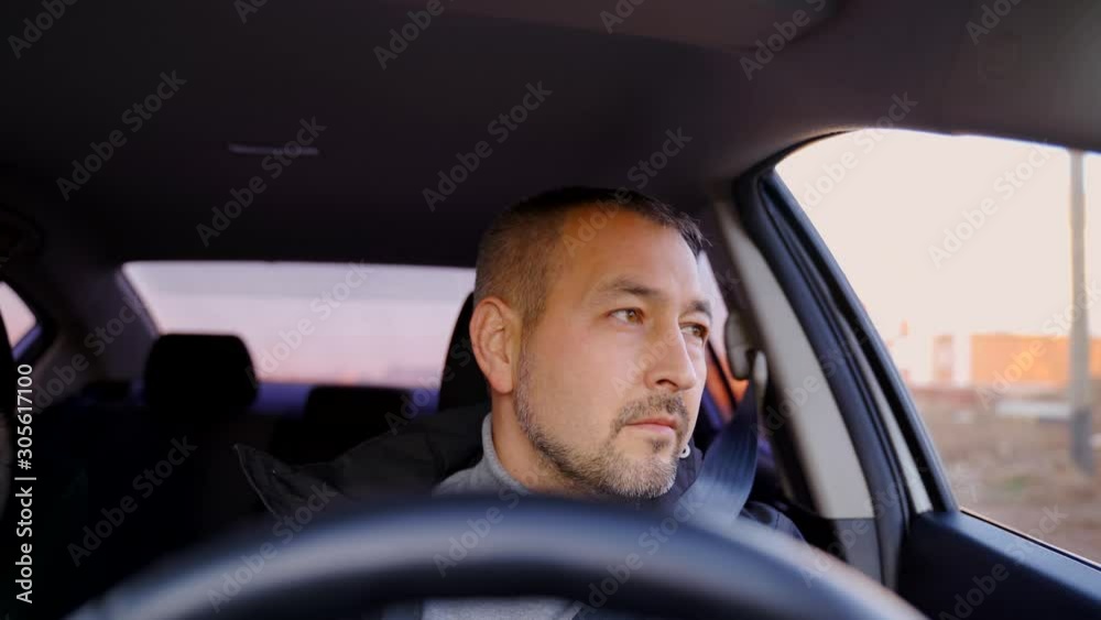 Portrait of a man with a short beard driving a car. Portrait of a man with a short beard driving a car.