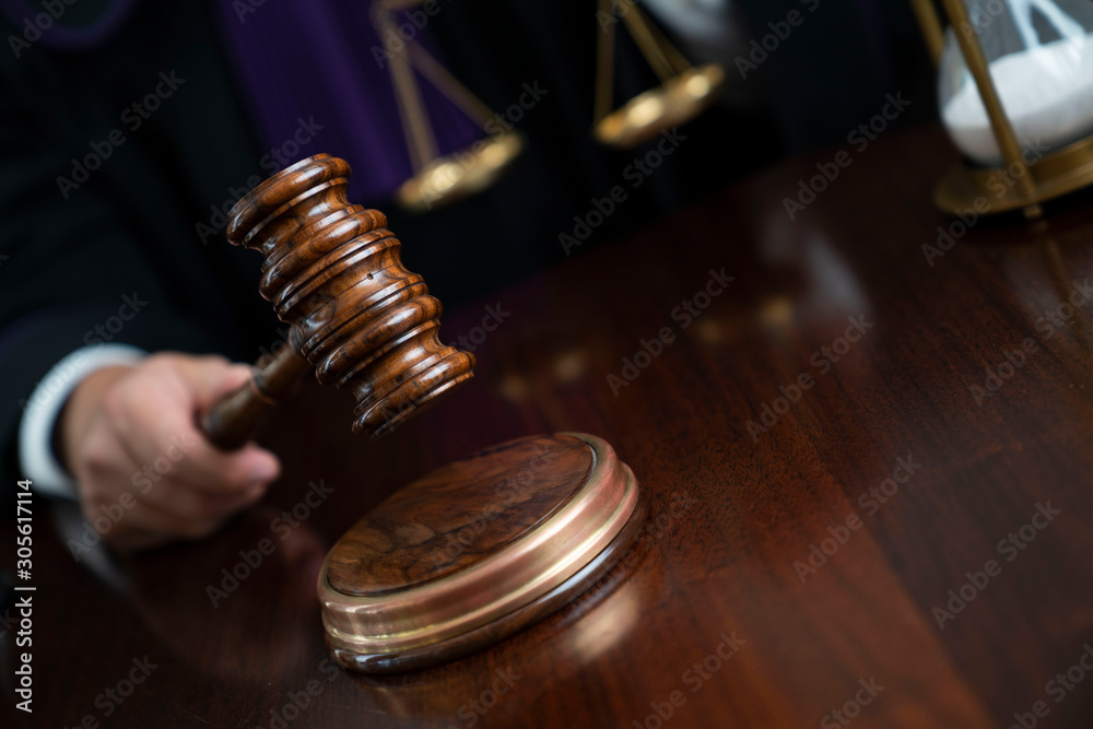 Judge giving the verdict and striking the gavel.