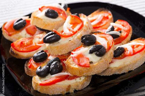 Tasty sandwiches  with cheese, tomato and olives at plate