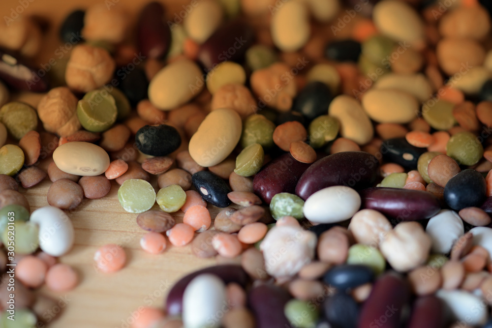 Different beans scattered on a wooden surface close-up. Naturel organic food background Different beans scattered on a wooden surface close-up. Naturel organic food background