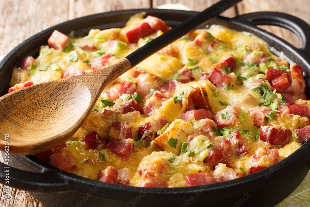 recipe for a simple strata with ham, bread, onions, cheese and eggs close-up in a pan. horizontal recipe for a simple strata with ham, bread, onions, cheese and eggs close-up in a pan. horizontal