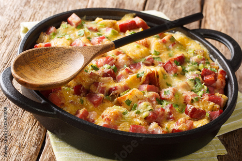 Strata bread casserole with ham, onions, cheese and eggs close-up in a pan. horizontal