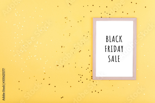 words BLACK FRIDAY SALE in white frame on yellow background with gold sequins.