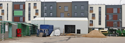 An industrial area for the collection and disposal of municipal waste is located next to standard buildings urban landscape